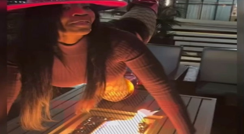 Woman sets hair on fire leaning over firepit for picture
