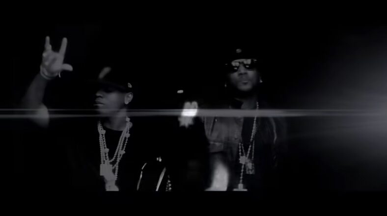 Young Jeezy and Plies performing in the "Lose My Mind" music video, standing together in a dark setting.