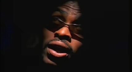 Coolio in a scene during the "Gangsta's Paradise" music video, which is a split going back-and-forth between he and Michelle Pfeiffer.