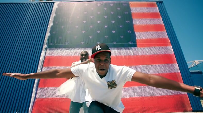 Jay-Z and Kanye West stunt in the "Otis" video, which premiered on August 11, 2011.