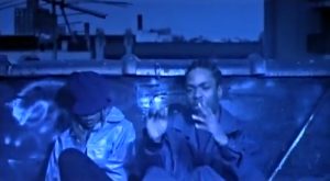 Method Man and Mary J. Blige in the "All I Need" music video, sitting on a rooftop in a blue-hued scene.