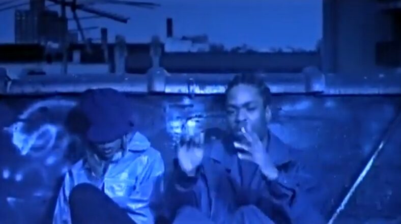 Method Man and Mary J. Blige in the "All I Need" music video, sitting on a rooftop in a blue-hued scene.
