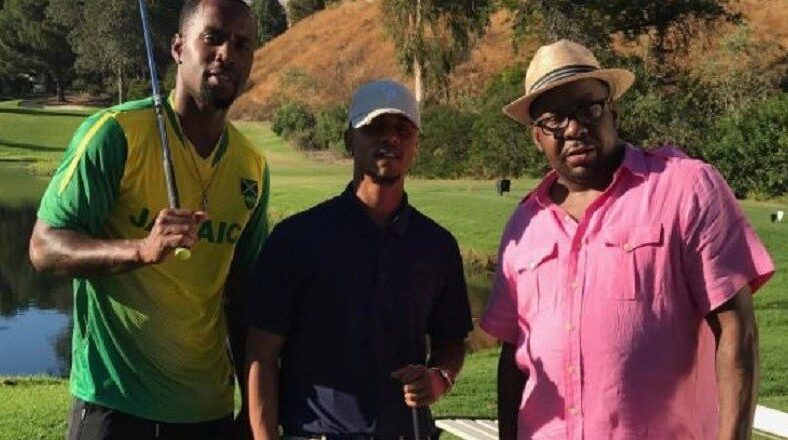 Bobby Brown stands with Lil Fizz and Safaree on a golf course, filming for "Love & Hip Hop Hollywood"