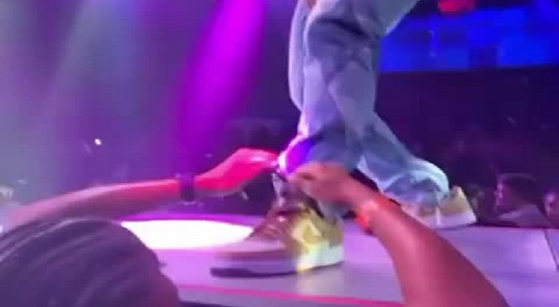 Fan ties Big Sean's shoe while he is performing