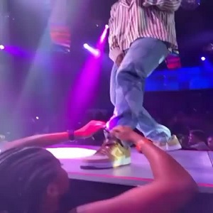 Fan ties Big Sean's shoe while he is performing