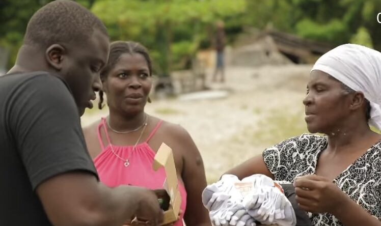 Zoey Dollaz distributing supplies to Haitian residents affected by the earthquake.