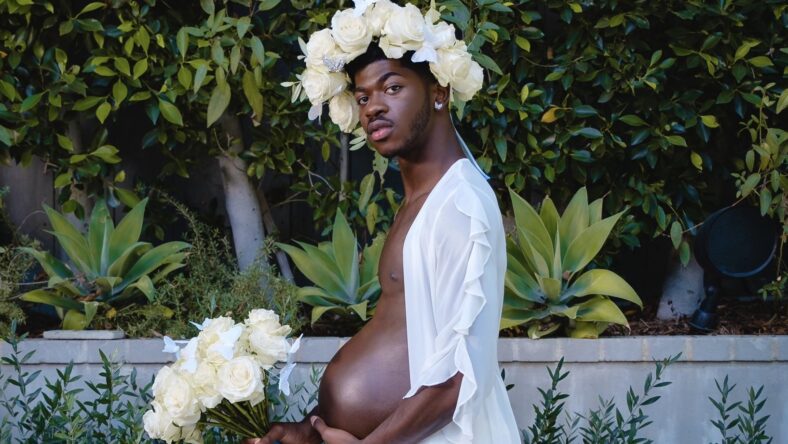 Lil Nas X poses with a pregnancy belly in a maternity-themed photoshoot to promote his album "Montero."