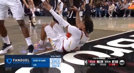 Kyrie Irving helps Darius Garland up after he gets hit between his legs