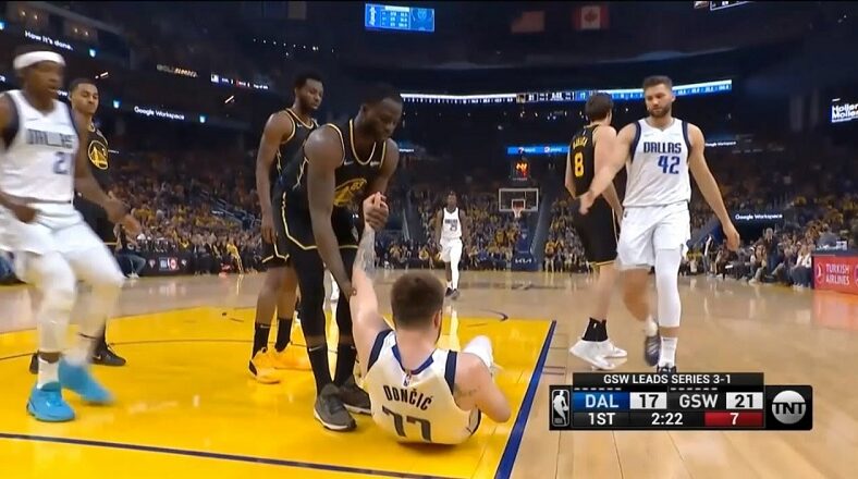 Draymond Green helps Luka Doncic up after blocking him