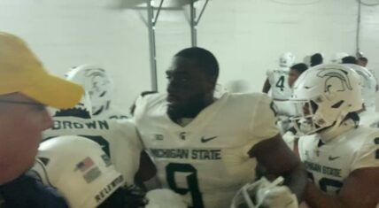 Michigan State's football team jump Michigan player after the game