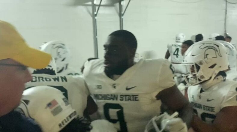 Michigan State's football team jump Michigan player after the game