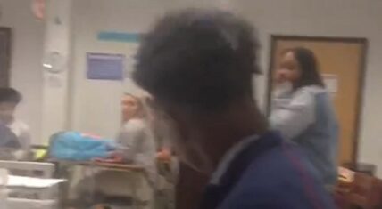 High school student smokes in class during teacher's lesson