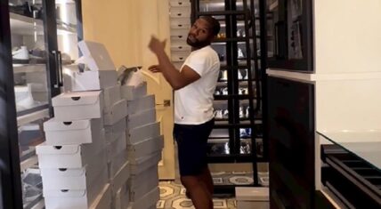 Floyd Mayweather standing inside of his large sneaker collection inside a custom-built closet.