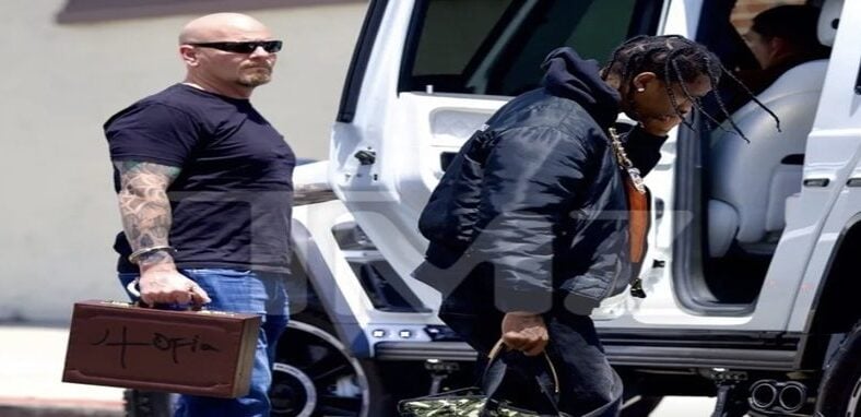 Travis Scott's security guard wears handcuffed "Utopia" briefcase