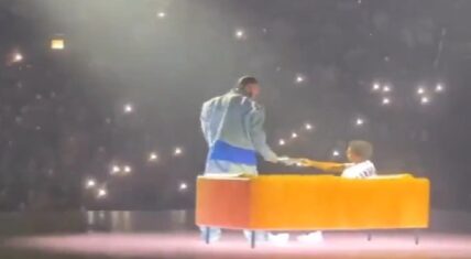 Drake's hologram hands him a book during his performance