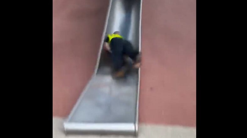Boston police officer falls backwards down children's slide