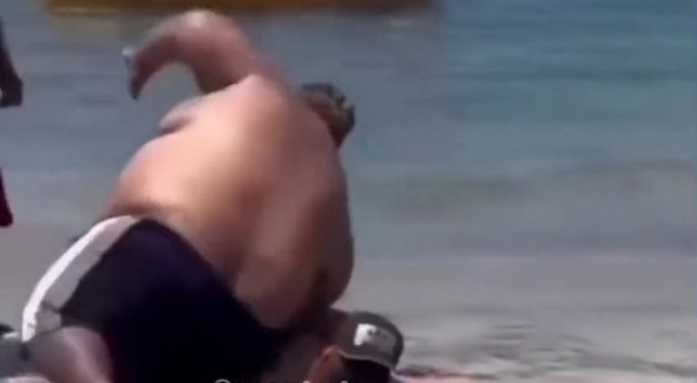 Overweight man falls on man sunbathing at the beach