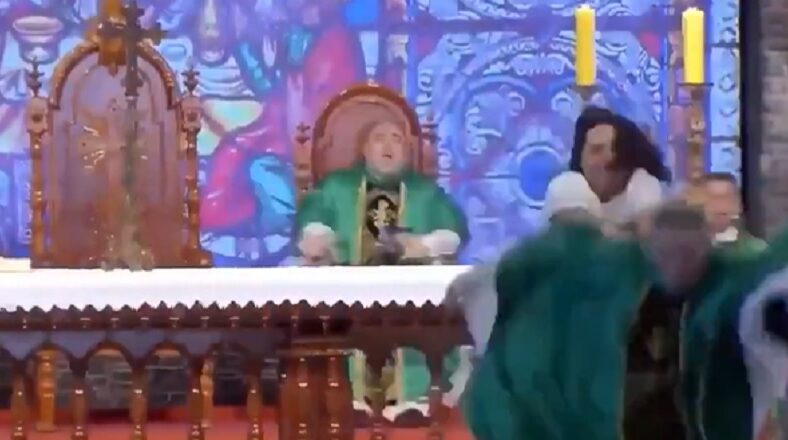 Woman shoves priest off stage in the middle of him preaching