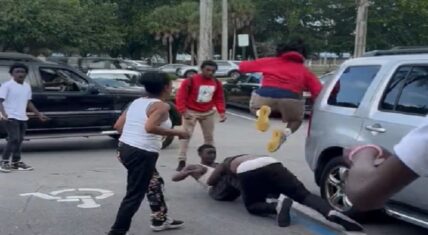 Man jumps on a guy's back in the middle of a fight