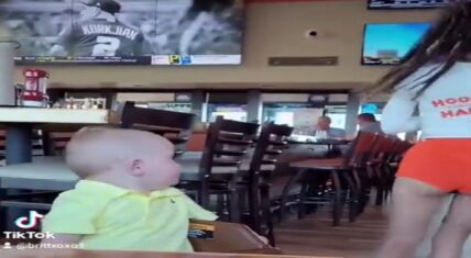 Toddler boy stops and checks out Hooters waitress