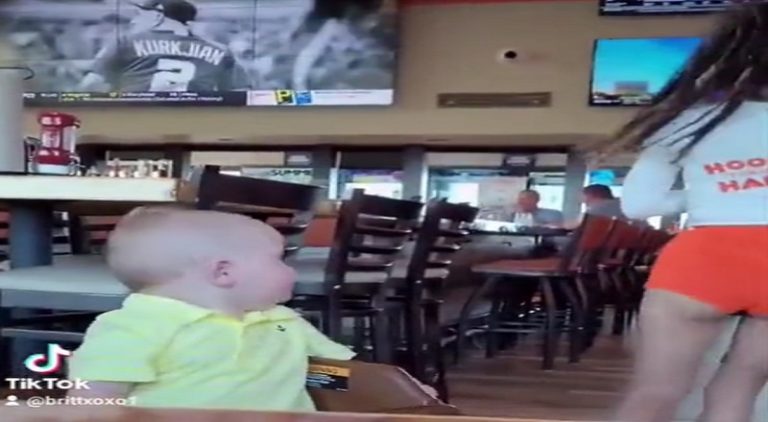 Toddler boy stops and checks out Hooters waitress