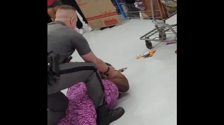 Cop has knee on woman's stomach during shoplifting arrest