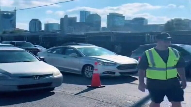Man wears safety vest to stop traffic so his friends can leave