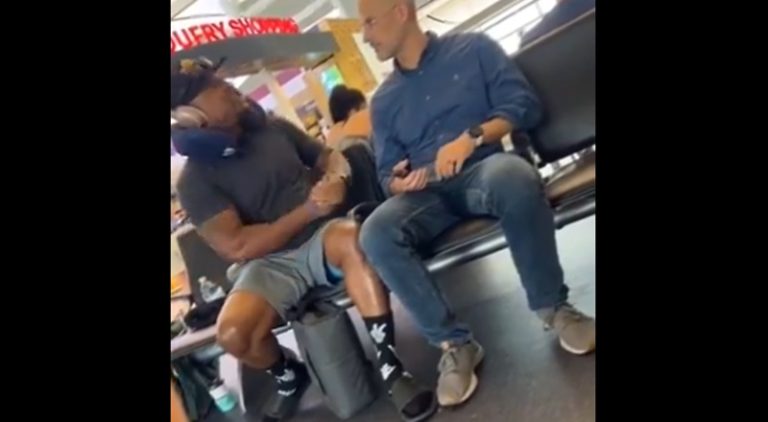 Man goes off on another man at airport for sitting beside him