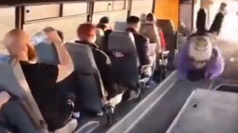 Man drinks water as man crashes through bus window