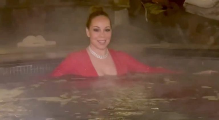 Mariah Carey jumps in the pool while wearing her dress