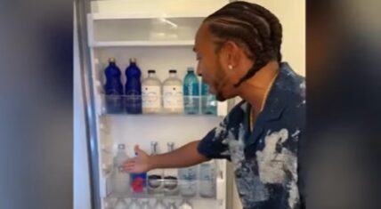Ludacris showing his refrigerator stocked with various premium water brands from different regions, including volcanic water from Hawaii, thermal water from Italy, and Alaskan glacier water.