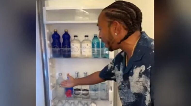 Ludacris showing his refrigerator stocked with various premium water brands from different regions, including volcanic water from Hawaii, thermal water from Italy, and Alaskan glacier water.