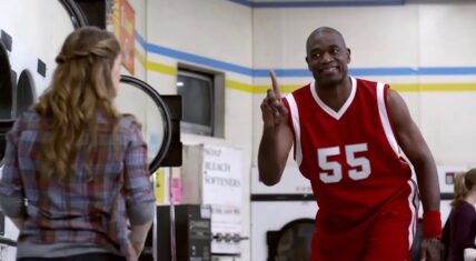Dikembe Mutombo in a commercial, wearing a red basketball jersey with the number 55