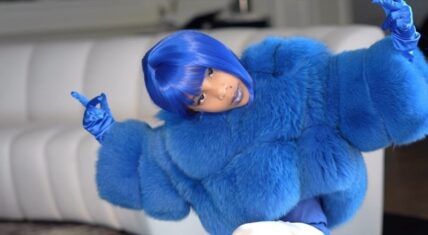 DJ Envy's daughter dressed in a blue wig and fur coat, inspired by Lil' Kim’s "Crush on You" music video.