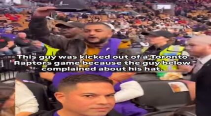 Fan holding up hat as security ejects him from Raptors game after another attendee's complaint