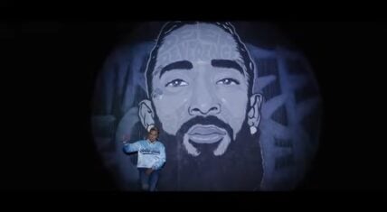 MC Lyte raps in front of Nipsey Hussle mural in "Make A Livin'" video