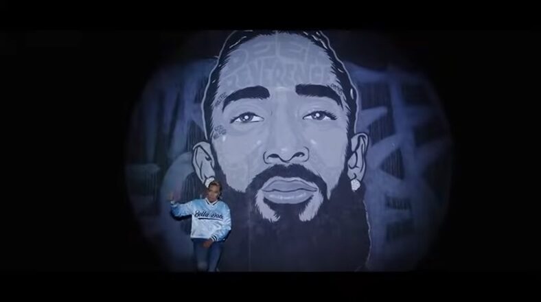 MC Lyte raps in front of Nipsey Hussle mural in "Make A Livin'" video