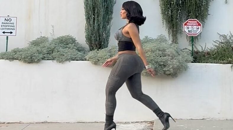Saweetie walking in a figure-hugging outfit, showcasing her bold style and confidence in a viral Instagram video.