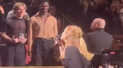 Lil Nas X standing in the front row at Adele’s Las Vegas concert as Adele waves.