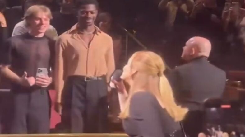 Lil Nas X standing in the front row at Adele’s Las Vegas concert as Adele waves.