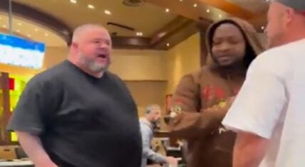 At a casino, there were two men who got into a heated confrontation. The man in the middle did his best to stop things from escalating.