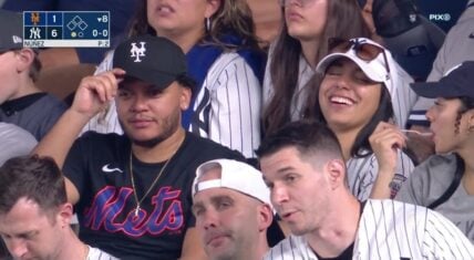 This couple took in the Mets-Yankees' game, but they are a house divided. The man is clearly a Mets fan and the woman is clearly a Yankee fan. As a result, they were having a lively conversation, as the Yankees were preparing for their win.