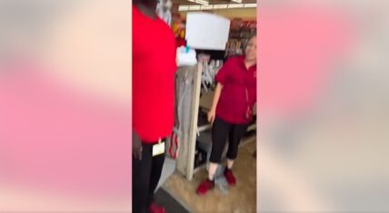 Family Dollar employee in red polo shirt facing a customer in a red t-shirt inside the Goldsboro, NC store during the viral confrontation video.