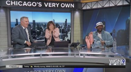 Marlon Wayans sits on the WGN Morning News desk in Chicago with his bare pedicured feet propped up, smiling as co-anchor Robin Baumgarten covers her face in hysterics and Larry Potash laughs beside her during the live segment.