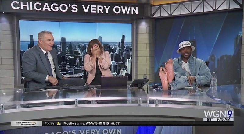 Marlon Wayans triggers news anchor’s foot phobia live on air by putting bare feet on desk, causing her to cover her face in horror [VIDEO]