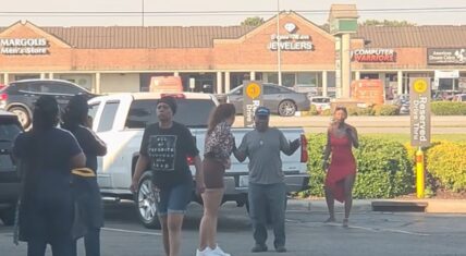 Woman in red dress confronting a group in a Jacksonville parking lot during McDonald's pies dispute incident.